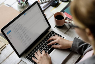 Mitarbeiter hat am Laptop das E-Mail-Programm geöffnet.
